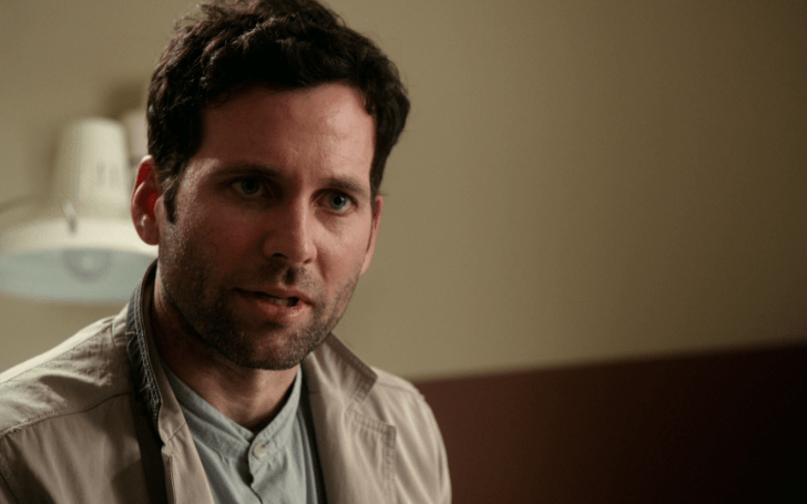 Eion Bailey caught on television acting wearing a grey coat.