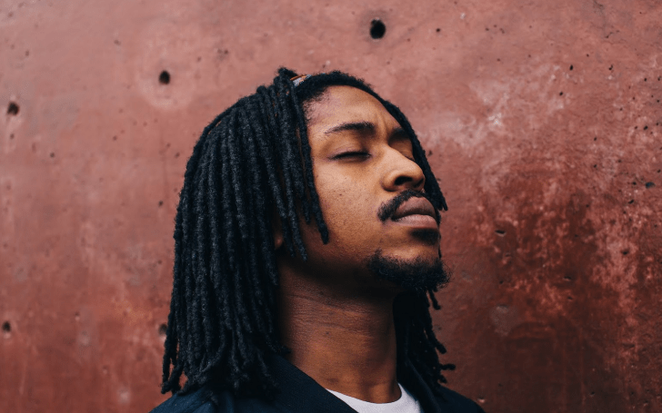 Iman Omari in a black jacket and white-tshirt