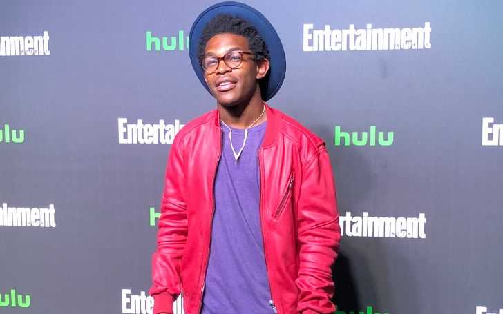 Camrus Johnson in a red jacket and blue t-shirt at a Hulu event.