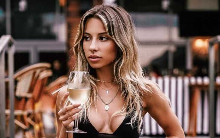 Ayla Woodruff looks beautiful in the low cut black dress with campagne glass on her right hand.