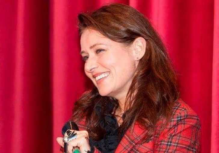 Sidse Babett Knudsen in a red dress at a mic.