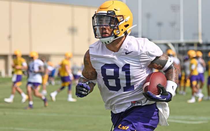 Thaddeus Moss in a white jersey and yellow helmet.